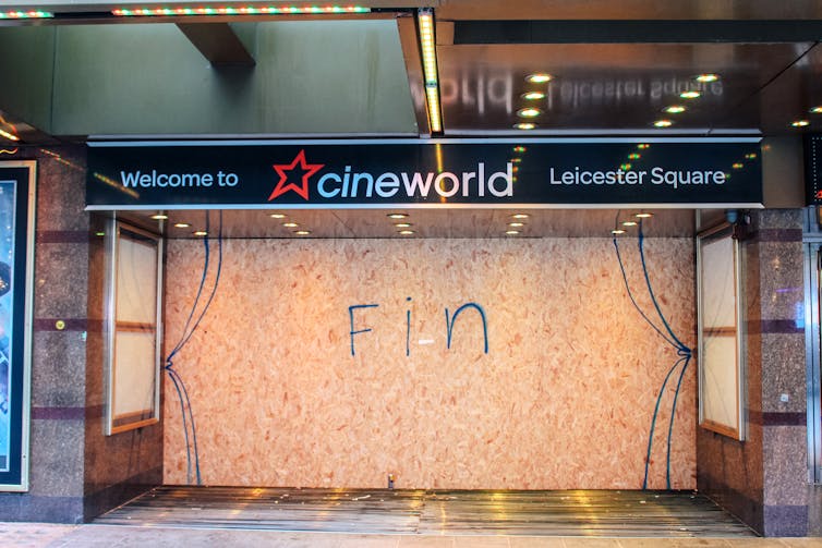 Cineworld cinema boarded up with Fin written over the shopfront in graffiti