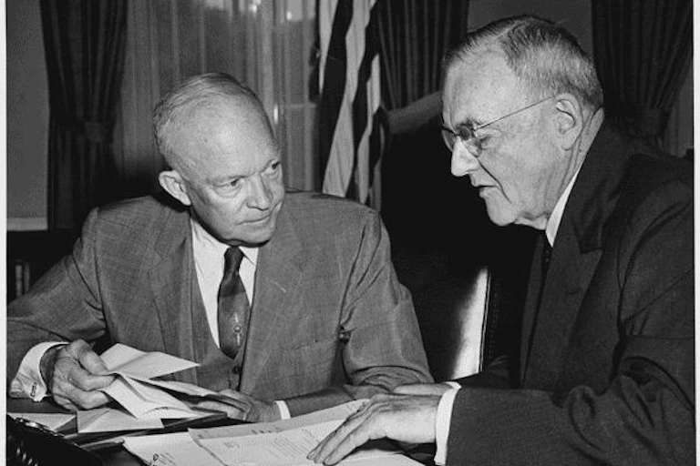 Two elderly white men examine a written document