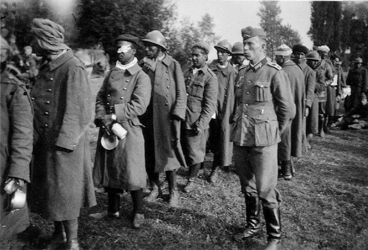 Colonial POWs from the French empire under guard by German soldiers, June 1940