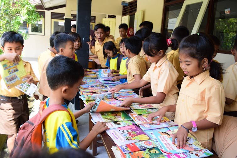 Siswa SDN 02 Ngijon di Sleman, Yogyakarta, melihat-lihat buku yang dibawa komunitas literasi Helobook. Lukman Solihin | conversation.com