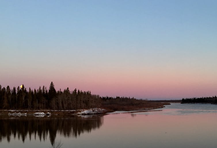 A lake and trees on both sides of the lake