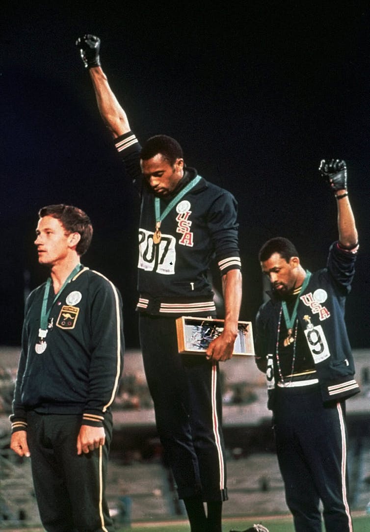 Australian Peter Norman, left, supported the Black Power protests of U.S. athletes Tommie Smith, centre, and John Carlos during the medal ceremonies for the 200 metre sprint at the 1968 Olympics. (AP Photo)