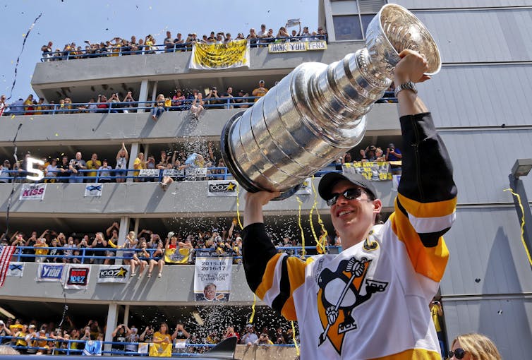 Sidney Crosby of the Pittsburgh Penguins hoists the Stanley Cup during last June’s victory parade in Pittsburgh, a city that has a long history of racial strife. Crosby and the Penguins have accepted Donald Trump’s invitation to visit the White House. (AP Photo/Gene J. Puskar)