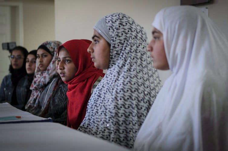 Young girls listen to Imam Syed Soharwardy, founder of Muslims Against Terrorism and the Islamic Supreme Council of Canada, speak about anti-radicalization strategies at a mosque in Calgary in October 2017. THE CANADIAN PRESS/Jeff McIntosh