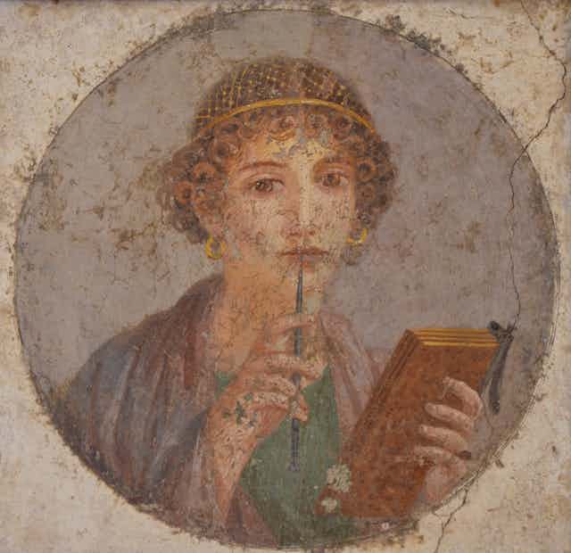 fresco of a woman holding a pen