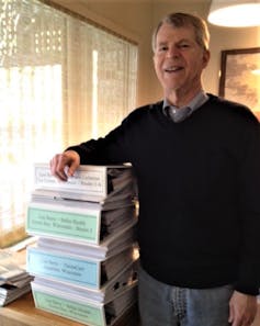 The author, Leonard Berry, stands by the seven binders of data he collected after studying three Wisconsin health systems. (Leonard Berry/Author, CC BY-SA)
