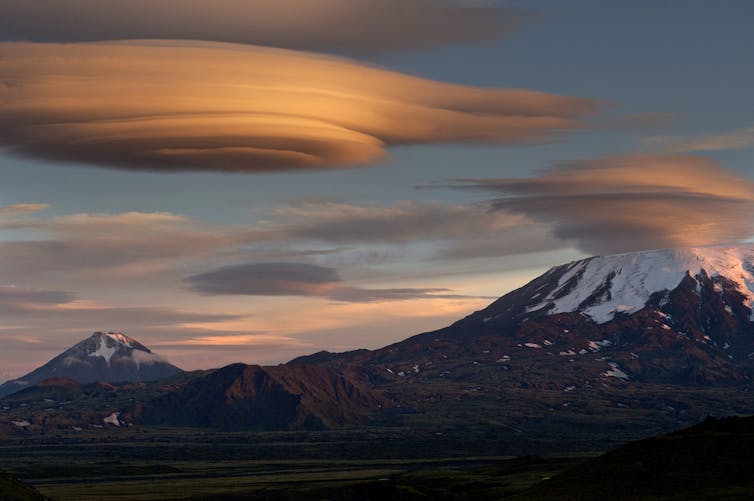 Lenticular clouds form over mountains.  (Shutterstock)