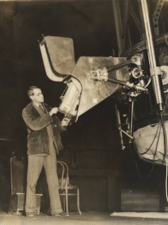 W. Merrill standing at the spectrograph mounted on the 60-inch telescope at Mount Wilson Observatory. Photo: Observatories of the Carnegie Institution for Science Collection at the Huntington Library, San Marino, California