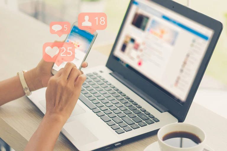 Image of someone holding a phone and receiving likes on social media.