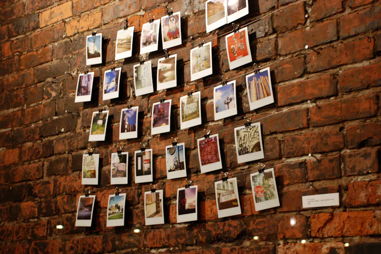 Polaroids clipped to a string agains brick wall