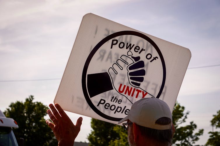 socialization <span class="caption">An activist at a Detroit, Michigan rally on June 14, 2018, holds a sign that says, ‘Power of the People’ to protest the separation of children at the border.</span>