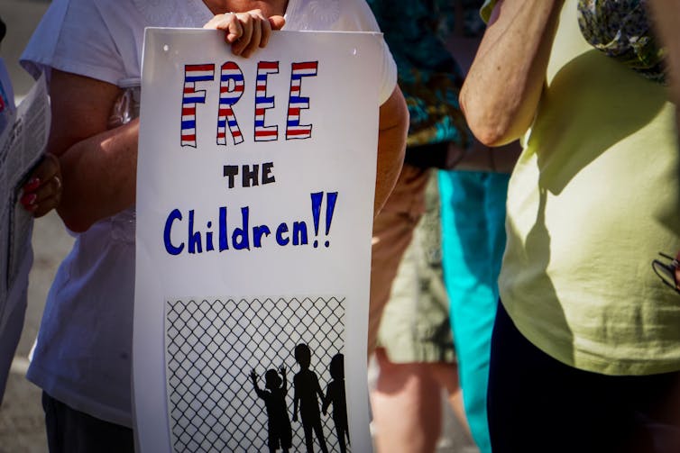 socialization On June 14, 2018: A protester at a Keep Families Together rally in Detroit, Michigan holds a sign that says, ‘Free the Children!!!’
