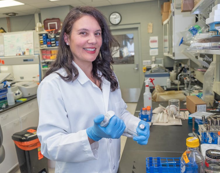 Alessandra Agostinho Hunt measures biofilm formation of Psuedomonas aerugionsa by pipetting in the purple dye crystal violet to stain the microbial structure.