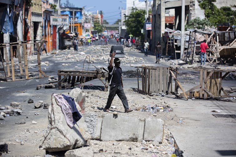 Protesters block a street with debris.