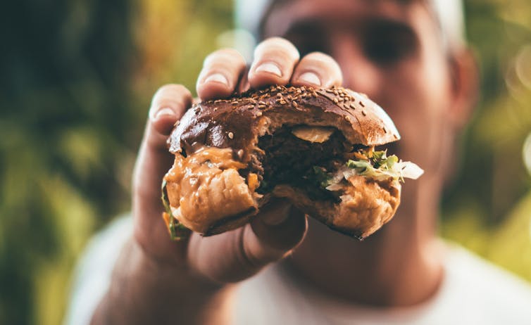 hand holding a hamburger