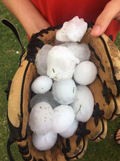 Large hailstones fill a baseball mitt
