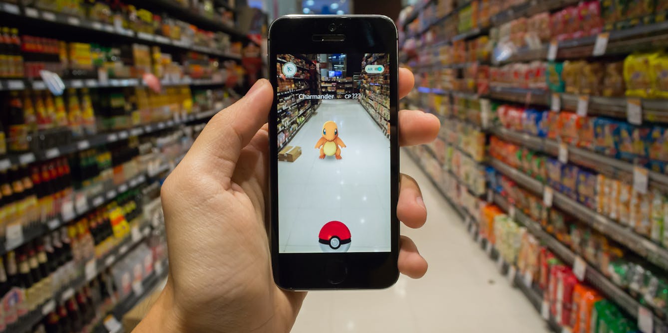 BANGKOK, Thailand - August 7, 2016: An IPhone User Playing Pokemon Go Game  In Supermarket Of Department Store And Find Pokemon Monster For Catching.  Free-to-play Augmented Reality Mobile Game Developed By Niantic.