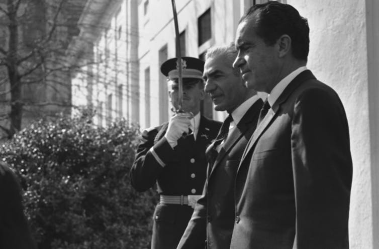 Us President Richard Nixon Stands Next To Iranian Shah Reza Pavlavi As A Soldier Holds Up His Sword In Salute.