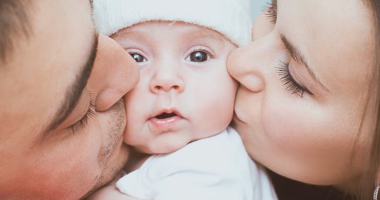 mom-and-dad-kissing-baby