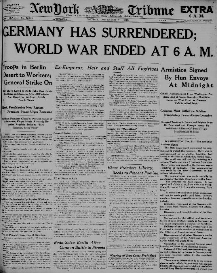 An old newspaper cover says in big black font, Germany has surrendered, World War ended at 6 AM