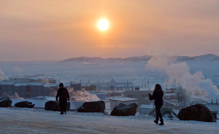 People walk along a path in Iqaluit, Nunavut in December 2014. - The Canadian Press