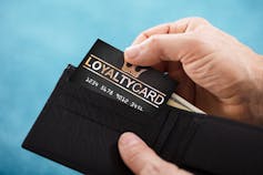 hands opening wallet and withdrawing a loyalty card