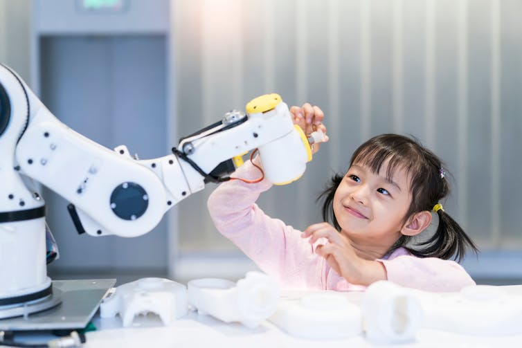 bambina che gioca con un robot
