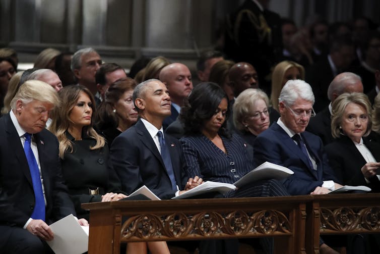Former presidents Donald Trump, Barack Obama and Bill Clinton, sitting alongside in a row,