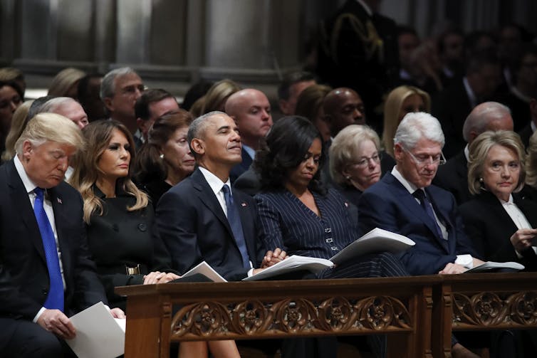 Former presidents Donald Trump,  Barack Obama and Bill Clinton, sitting alongside in a row,