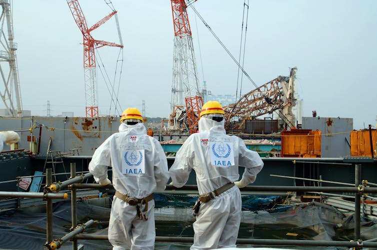 Two IAEA agents examine work Unit 4 of the Fukushima Daiichi Nuclear Power Station (April 17, 2013).Greg Webb/IAEA, CC BY