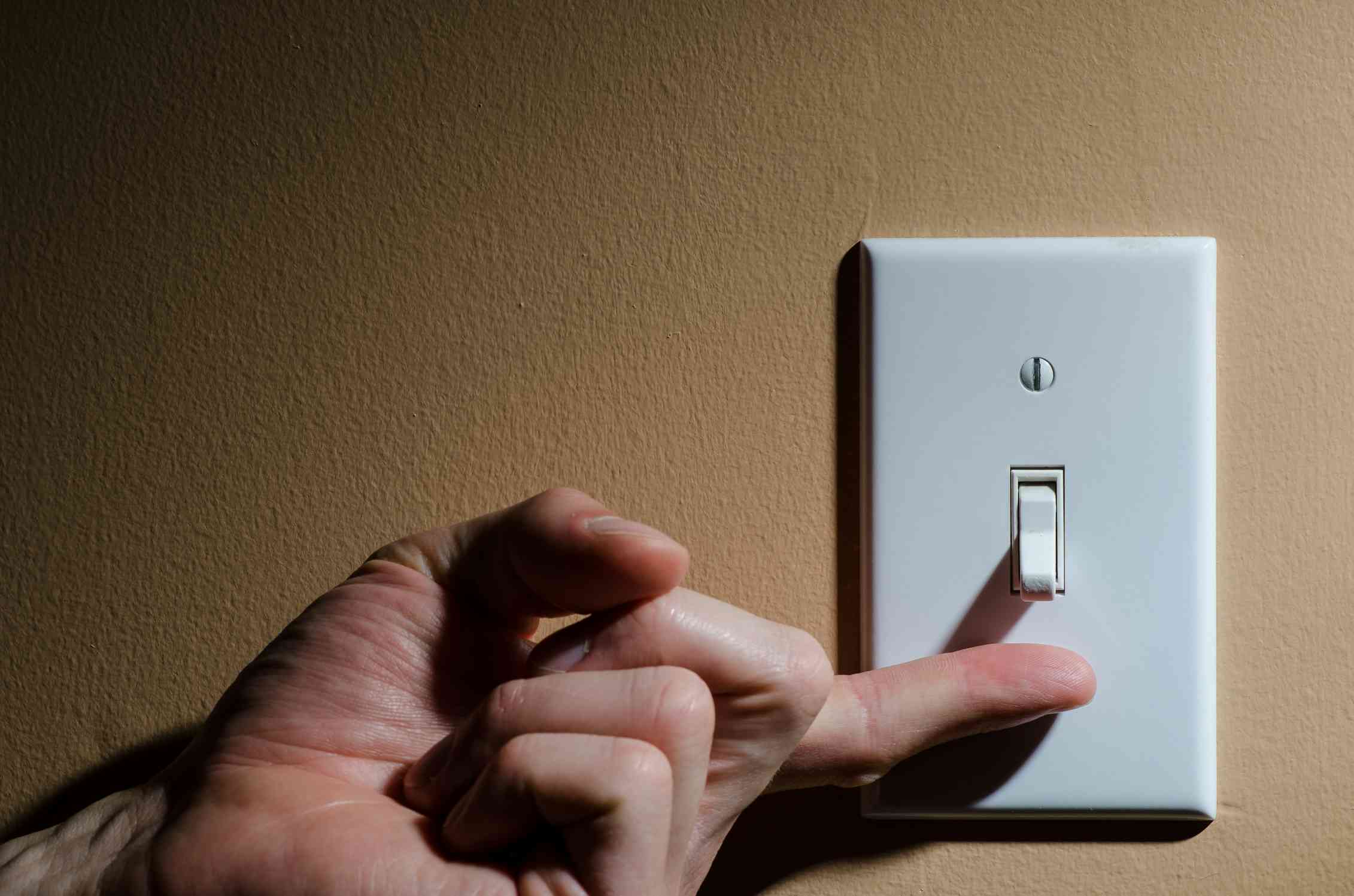 Включенный выключатель. Человек выключает свет. Рука на выключателе. Can you turn off the light