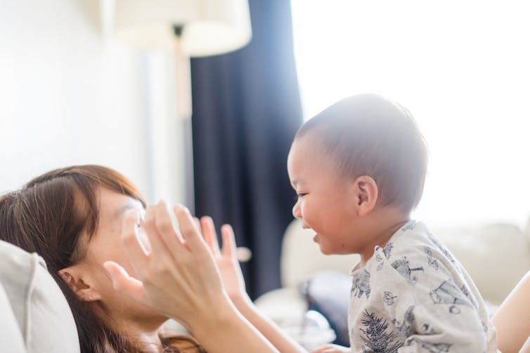 Mom playing peek-a -boo with a child