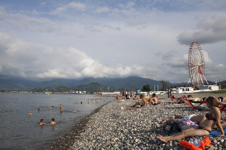 Tourists swim and sunbathe in the Black Sea resort town of Batumi