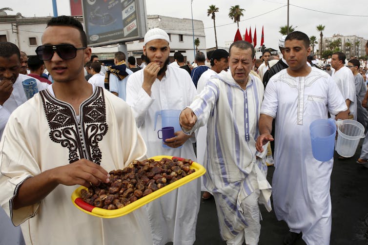 People distribute food and drinks during the Eid celebrations in Casablanca, Morocco. By AP Photo/Abdeljalil Bounhar