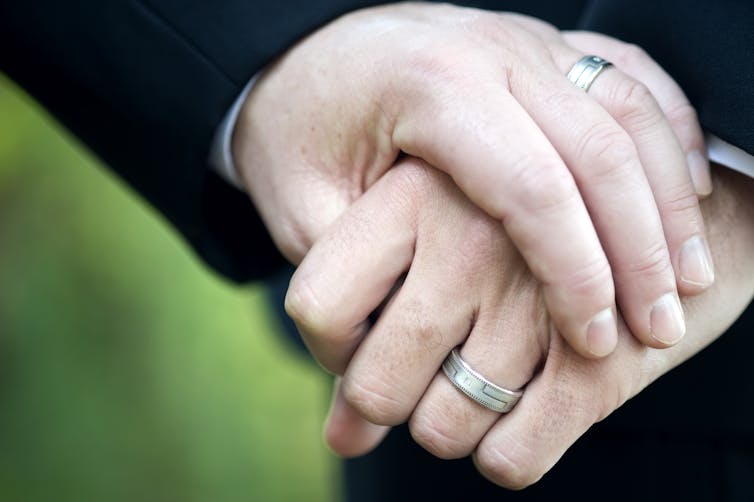 hand resting on hand with wedding ring