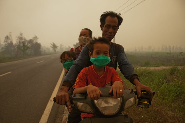 A family rides through thick haze in Kalimantan, 2015. Aulia Erlangga/CIFOR, CC BY-NC-SA