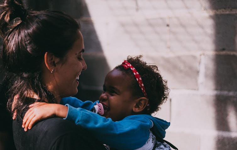 Woman holding smiling toddler