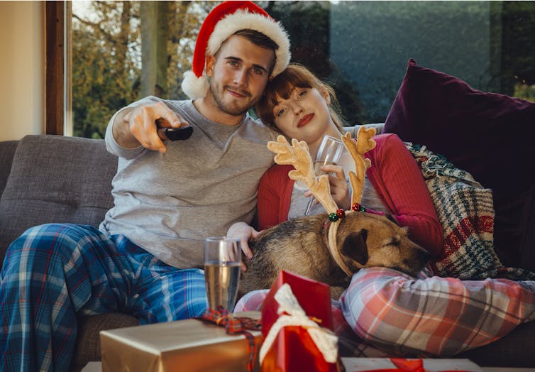 A couple on a couch watching a movie.