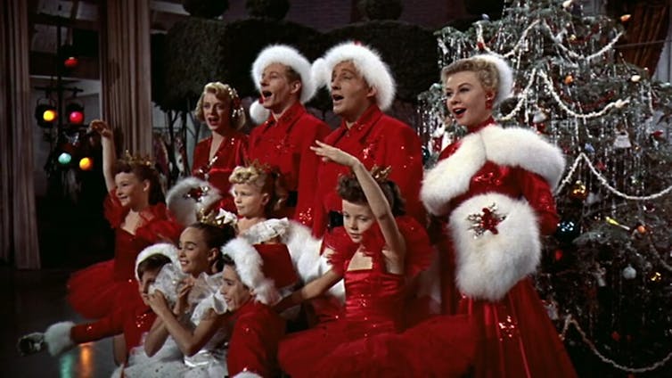 O elenco de 'White Christmas' diante de uma árvore de Natal.