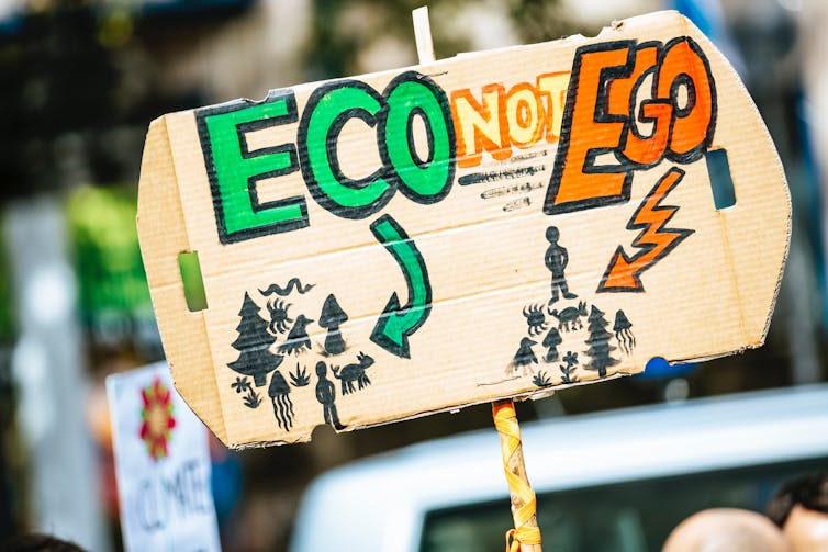 Protest sign at climate protest reading 'Eco not Ego'