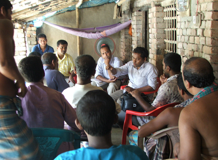 Farmers meet in a group on an outdoor patio
