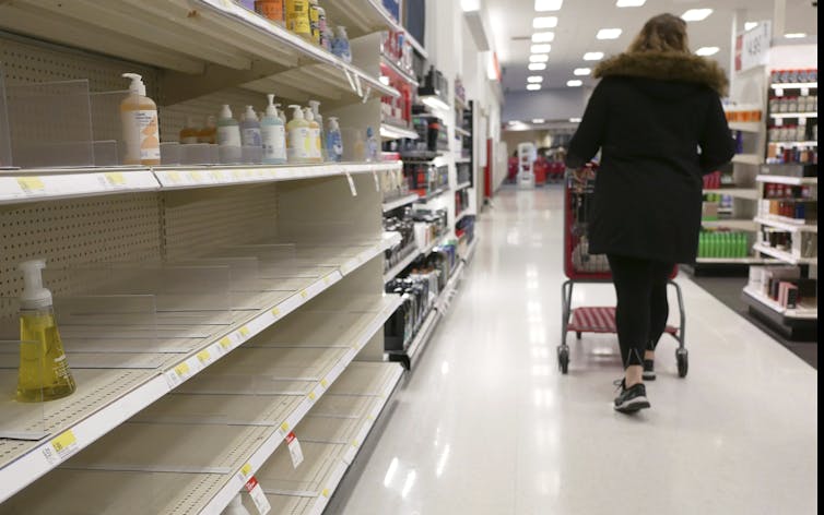 Woman walking through bare store aisle