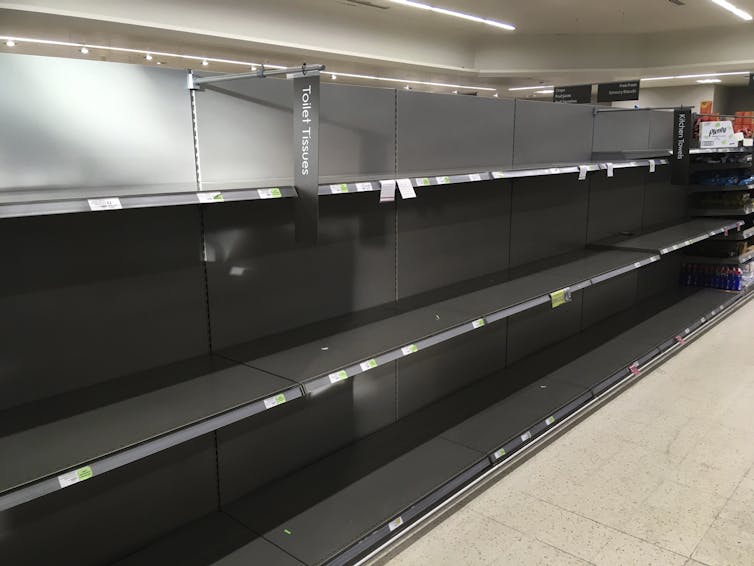 Shelves stand empty in the aisle for toilet paper at the Waitrose supermarket in Surbiton, south west London, on March 11, 2020