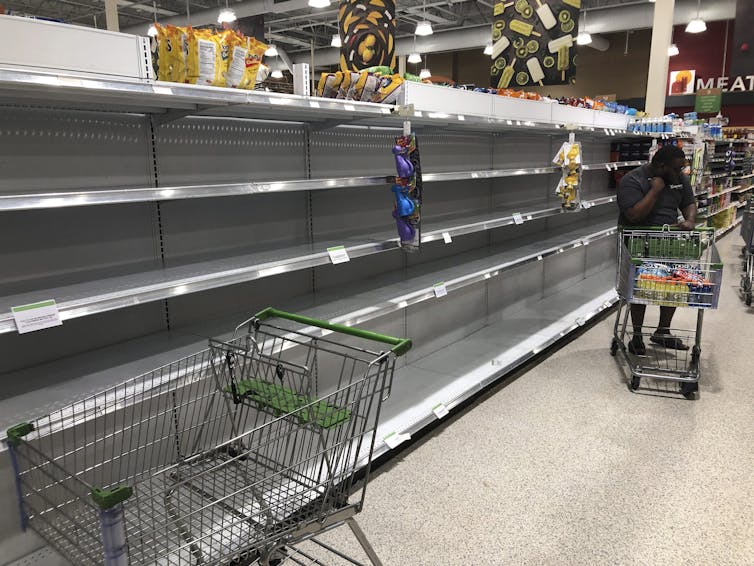 Empty shelves where water is sold at a grocery store are shown in August 2019, in North Miami, Fla. as Hurricane Dorian approached