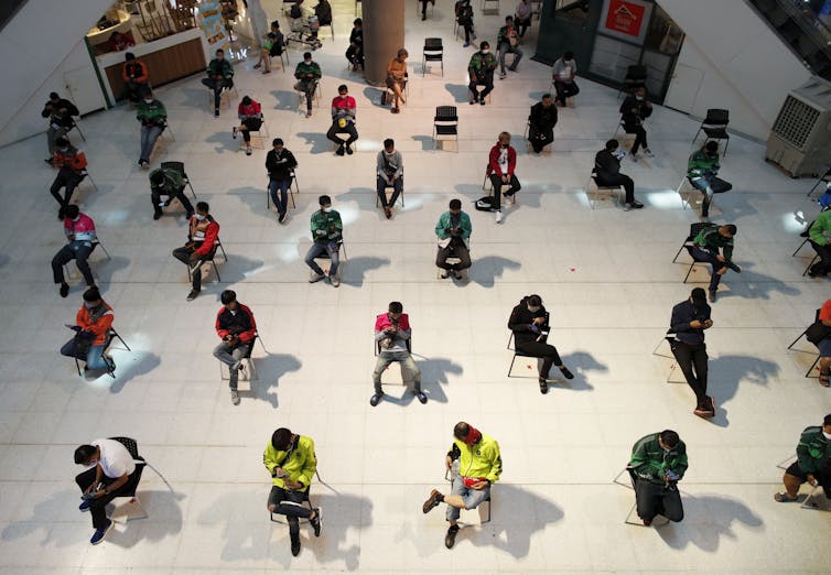 Food delivery workers await the orders of customers in self-isolation. Bangkok, Thailand, March 24 2020.