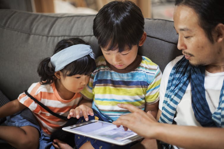 father and children on tablet to enhance family health