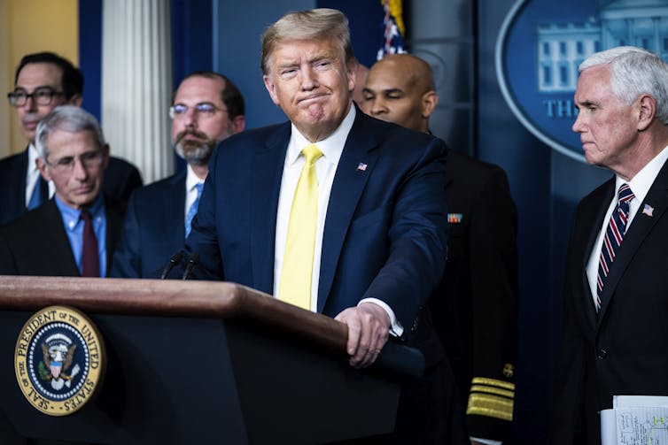 President Trump at press briefing with members of his cabinet standing in the background