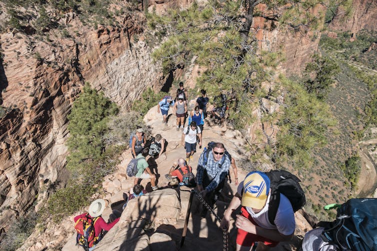 Tourists hiking up mountain, photo