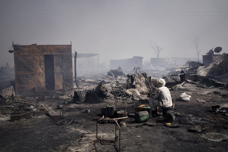 Person sitting in middle of rubble