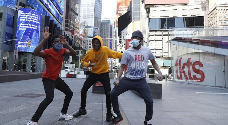 Three boys dancing in Times Square, New York City. 